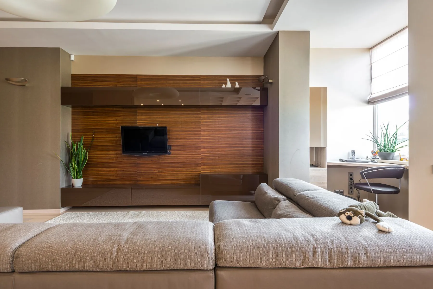 Sala com painel de madeira e móvel de televisão